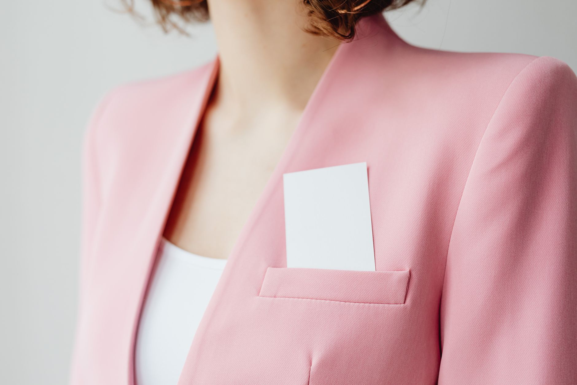 Close-up of a professional in an office holding a smart NFC card with a visible dot chip, representing a modern Dot Business Card solution.